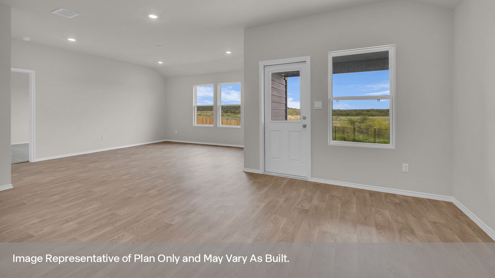 Dining area with 1 large window and a backdoor and living room with two large windows.