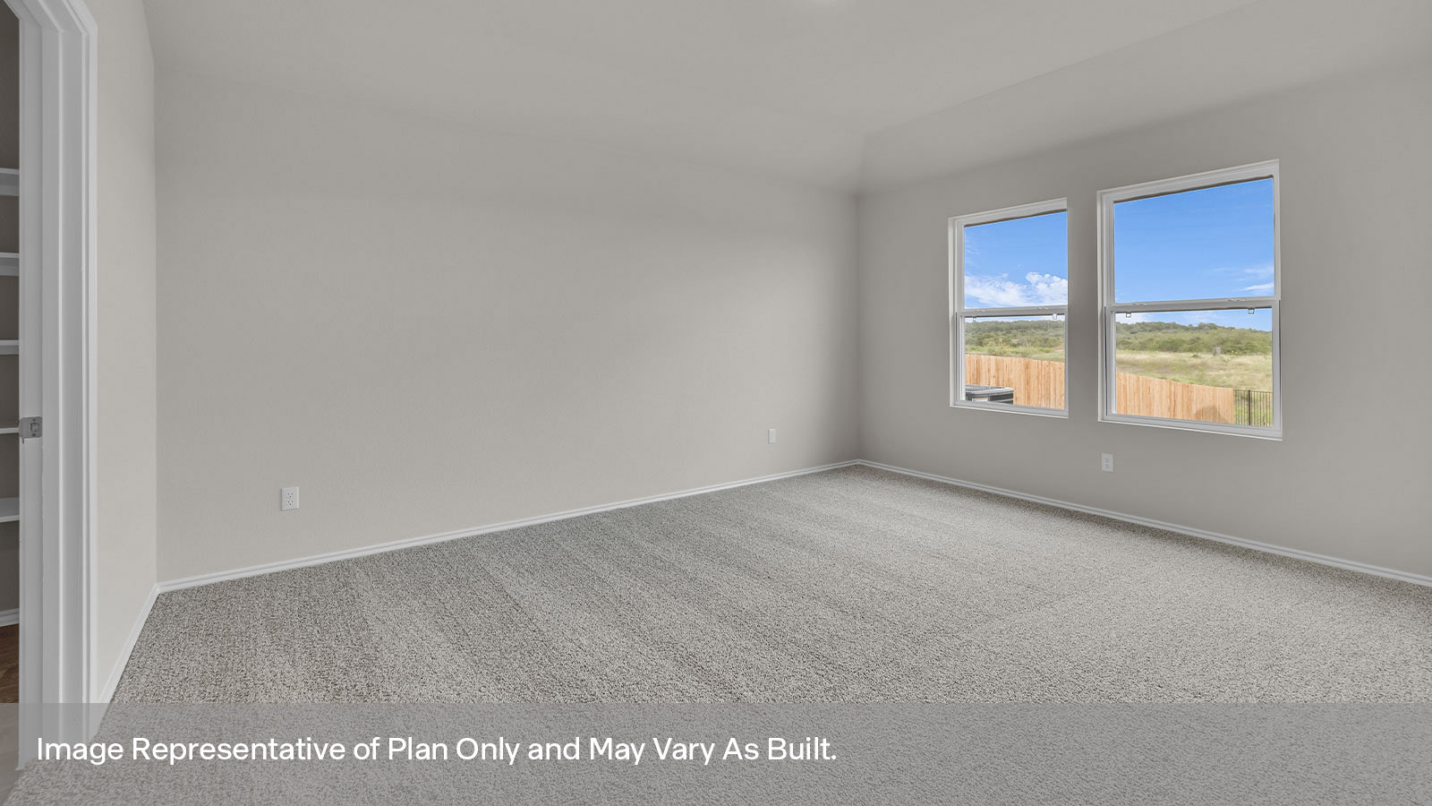 Main bedroom with carpet and two windows.