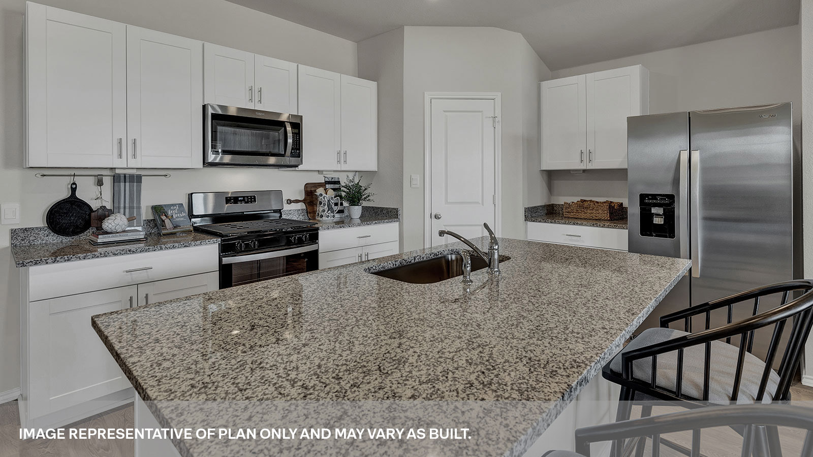 Kitchen with a kitchen island and large sink and appliances.