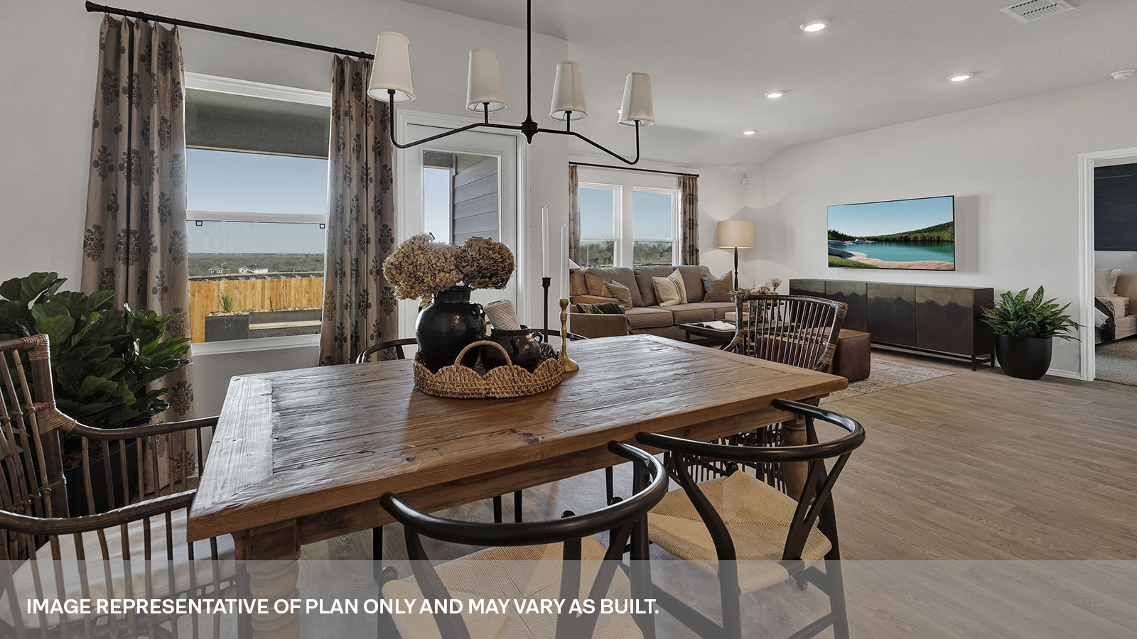 Dining area with 1 large window and a backdoor and living room with two large windows.
