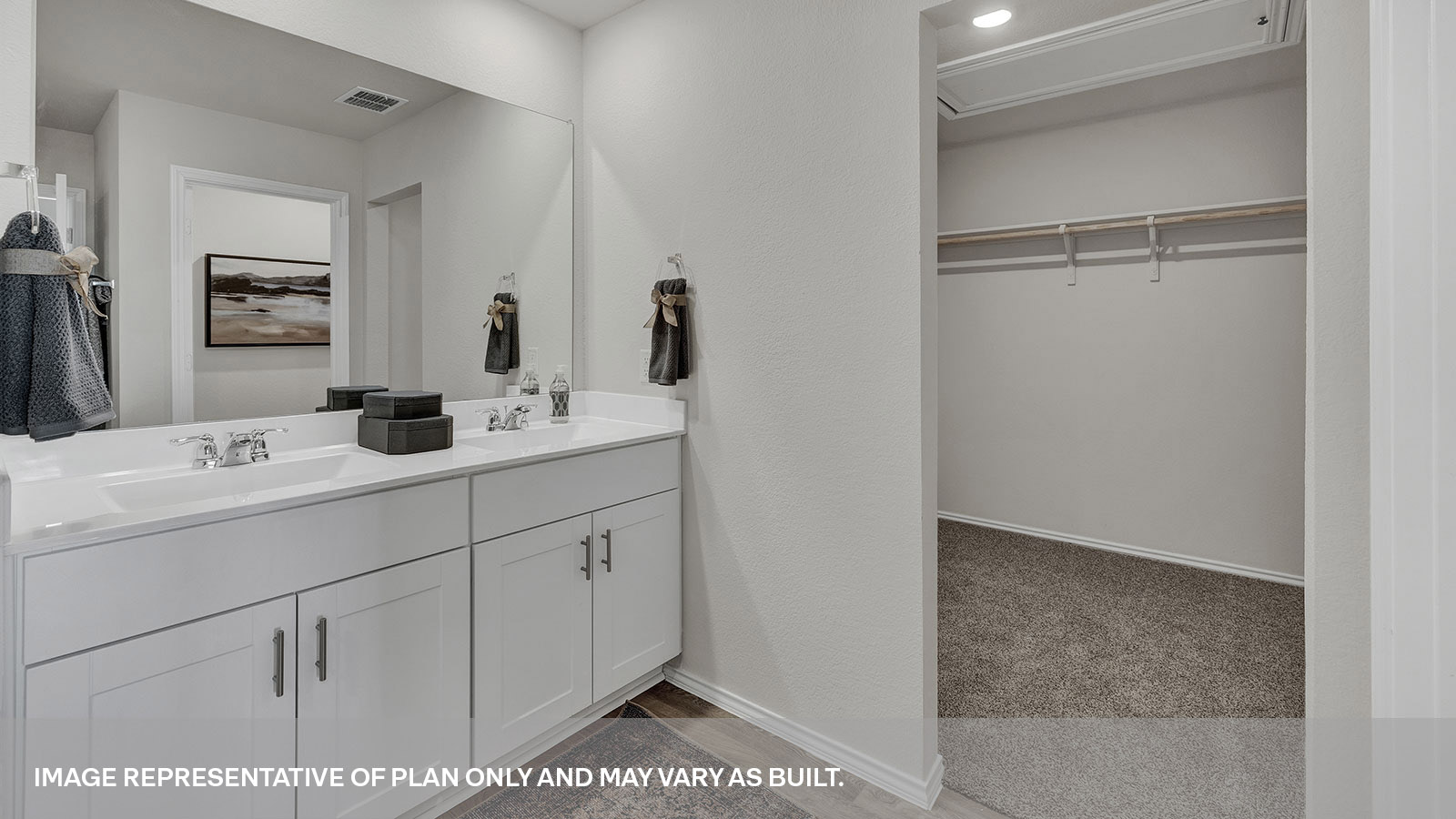 Main bathroom with a double sink and walk-in closet.