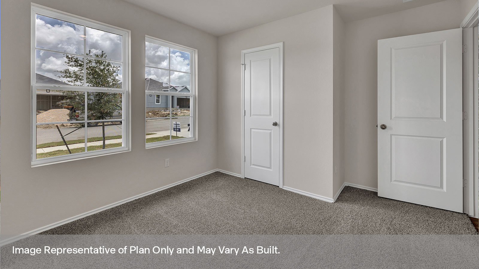 Front bedroom with carpeting and two windows.