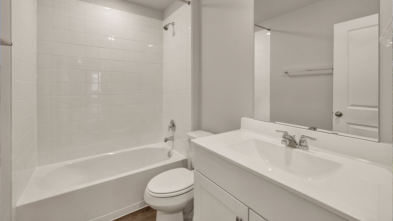 Hall bathroom with single sink vanity, toilet, and tub.
