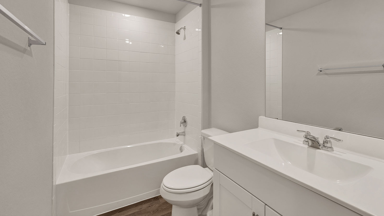 Hall bathroom with single sink vanity, toilet, and tub.