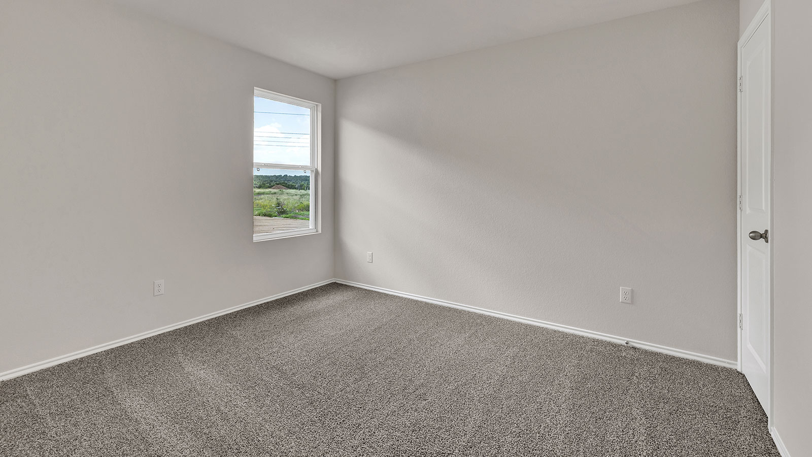 Bedroom with carpeting and one window.