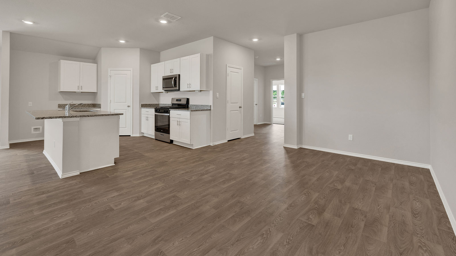 Kitchen with white cabinets and entry hallway.