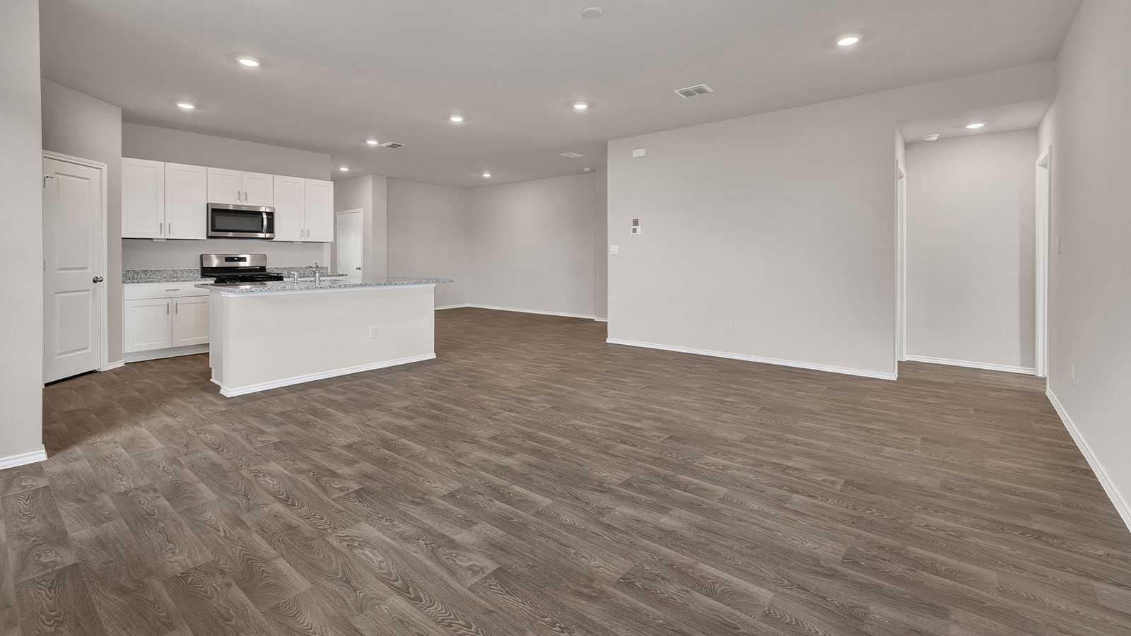 Living room with vinyl flooring and two windows.