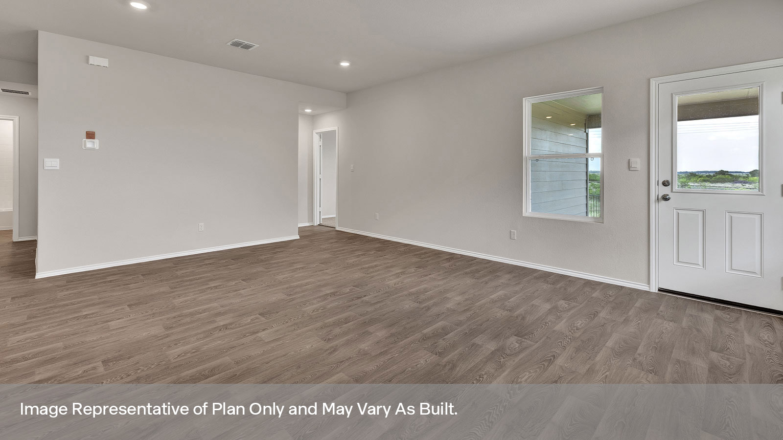 Living room with vinyl flooring, 3 windows, and half lite exterior door.