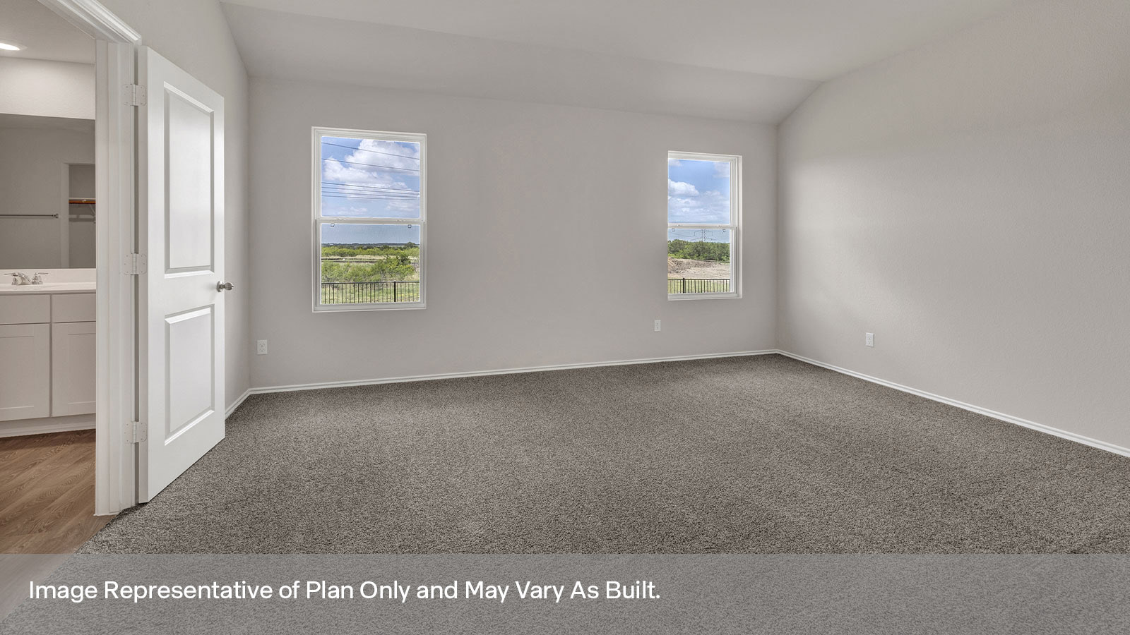Main bedroom with carpeting and two windows.