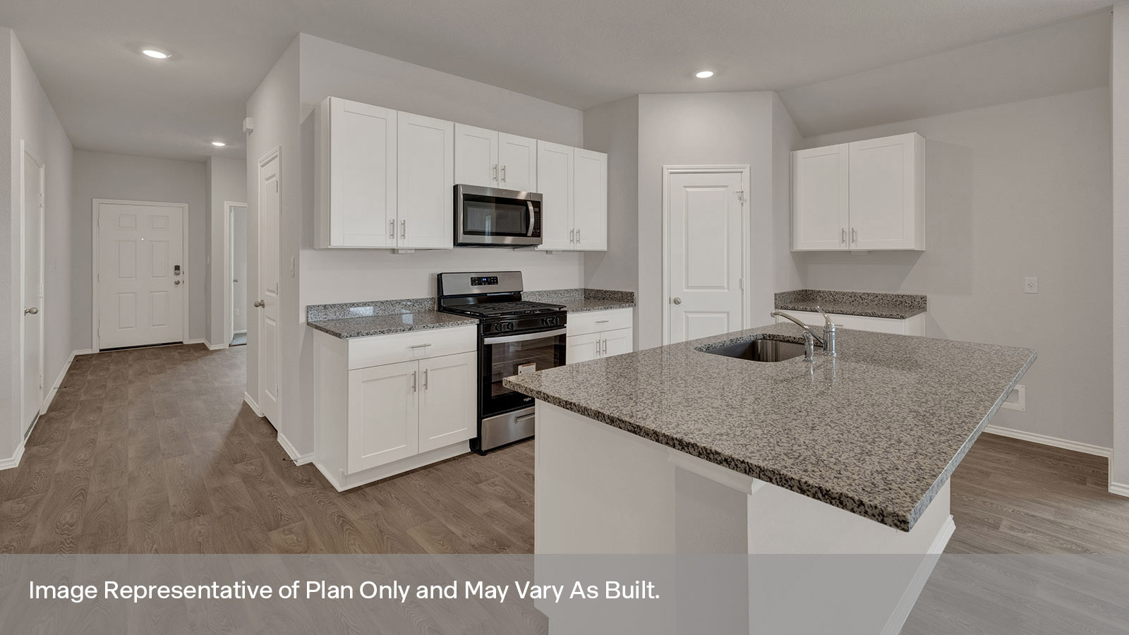 Kitchen with kitchen island and entry hallway.