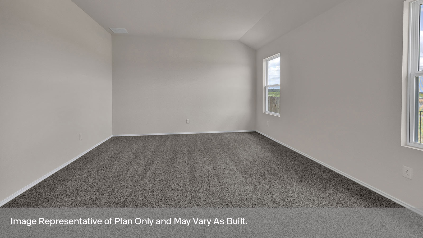 Main bedroom with carpet and two windows.