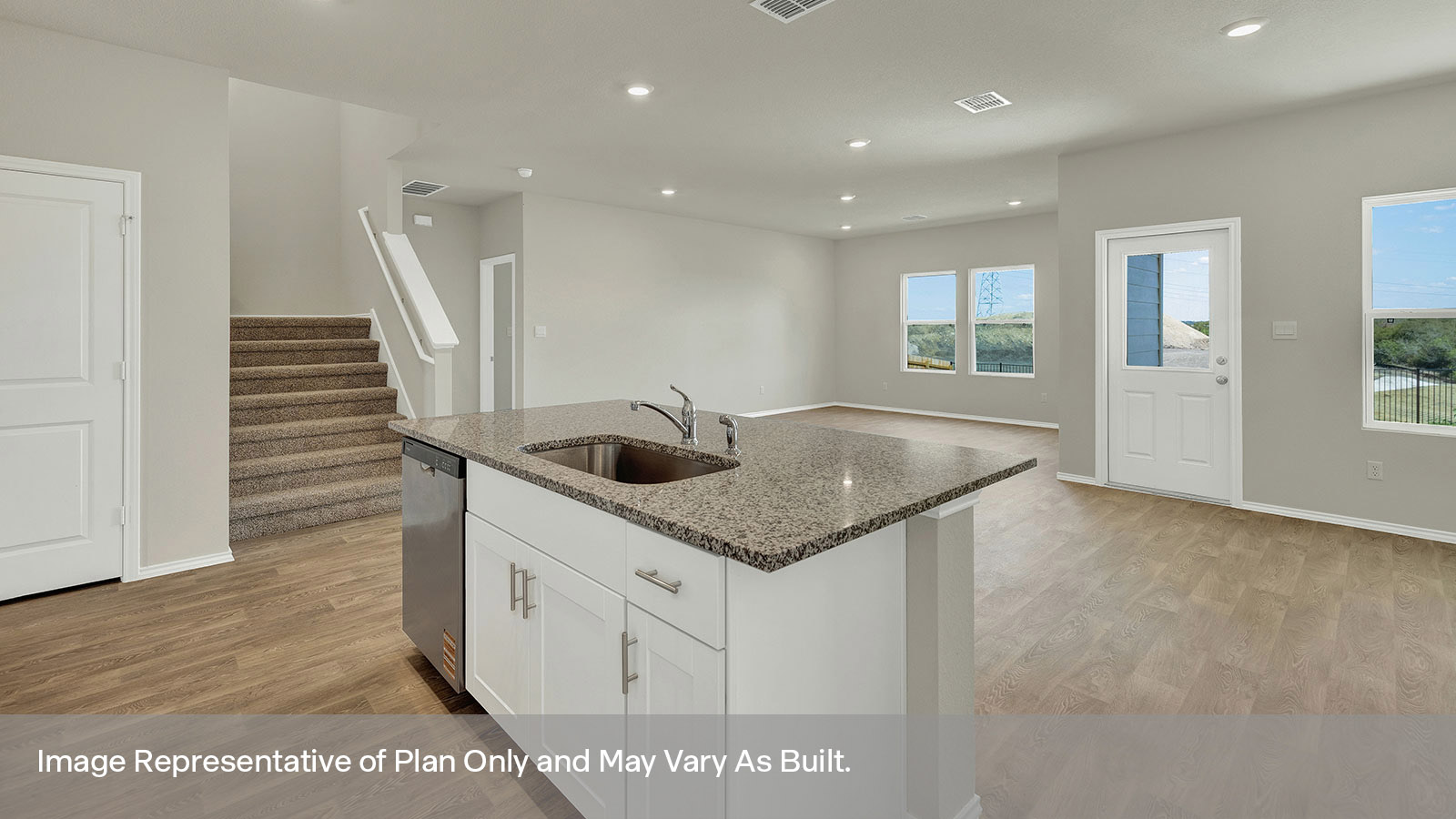 Kitchen with kitchen island and stairs to the 2nd floor.