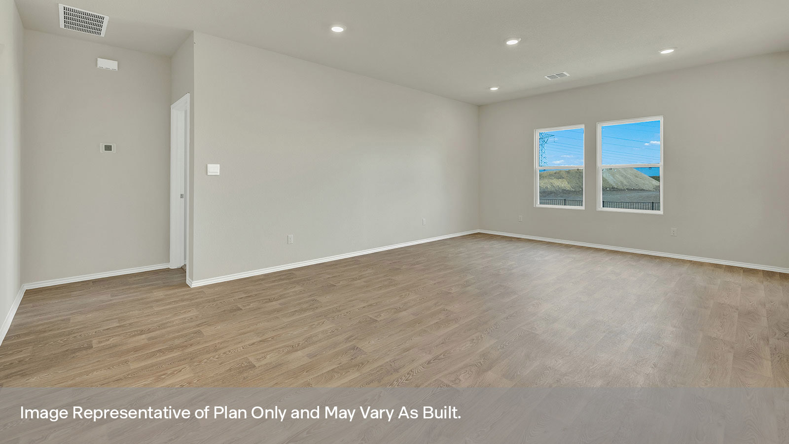 Living and dining room with vinyl flooring, 3 windows, and a half lite exterior door.