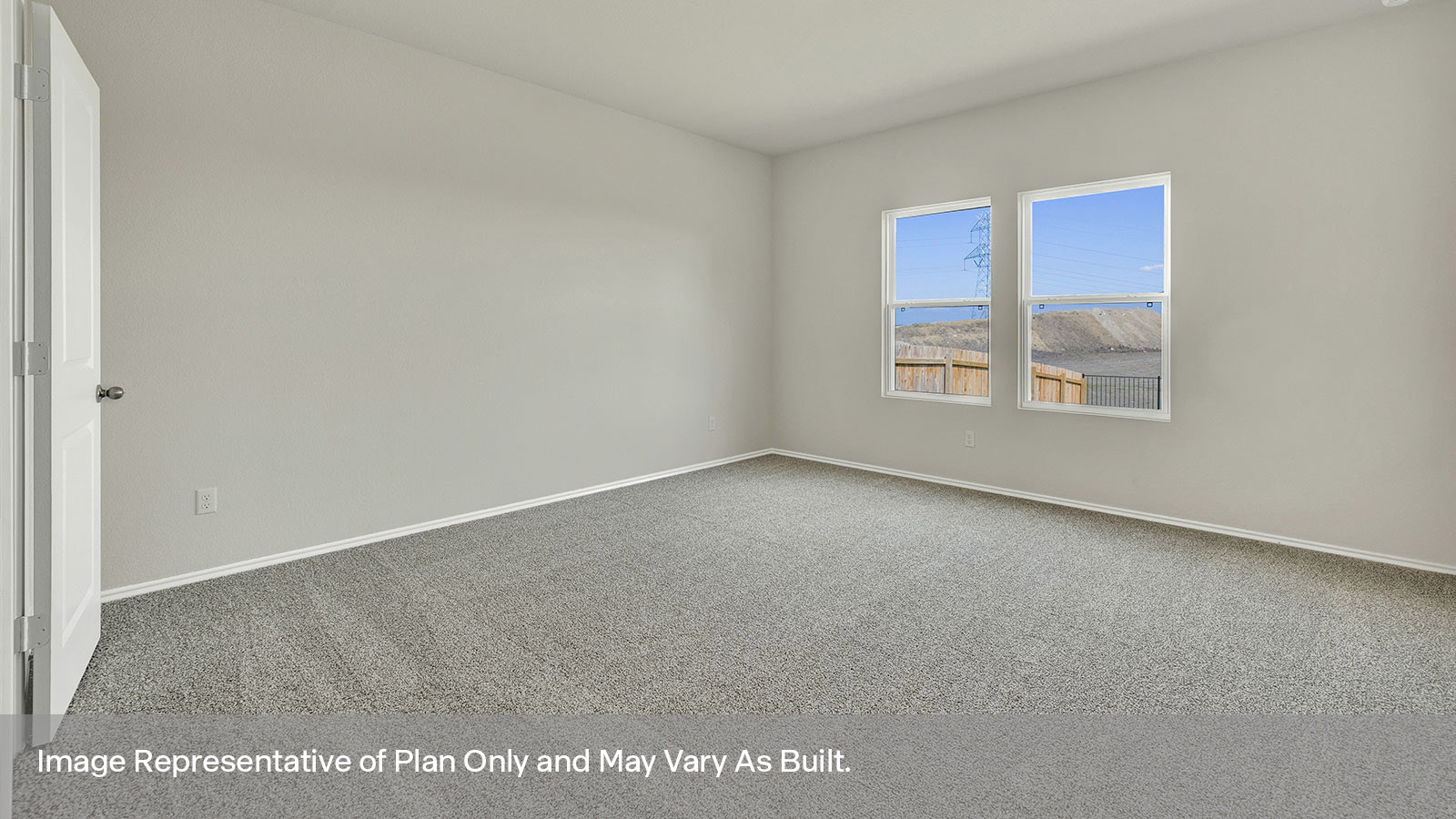 Main bedroom with carpeting and two windows.