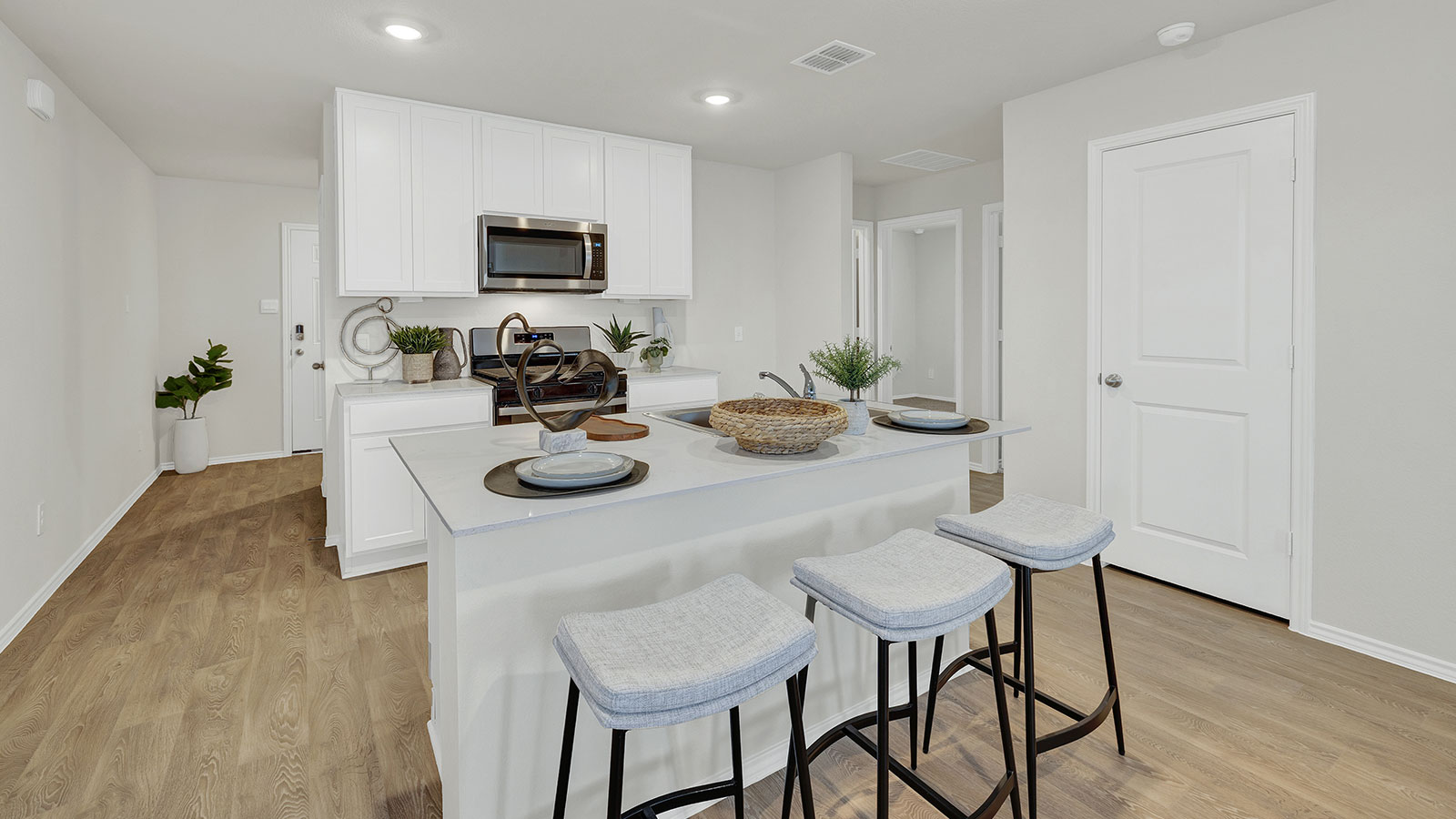 Staged Kitchen with kitchen island and white cabinets.