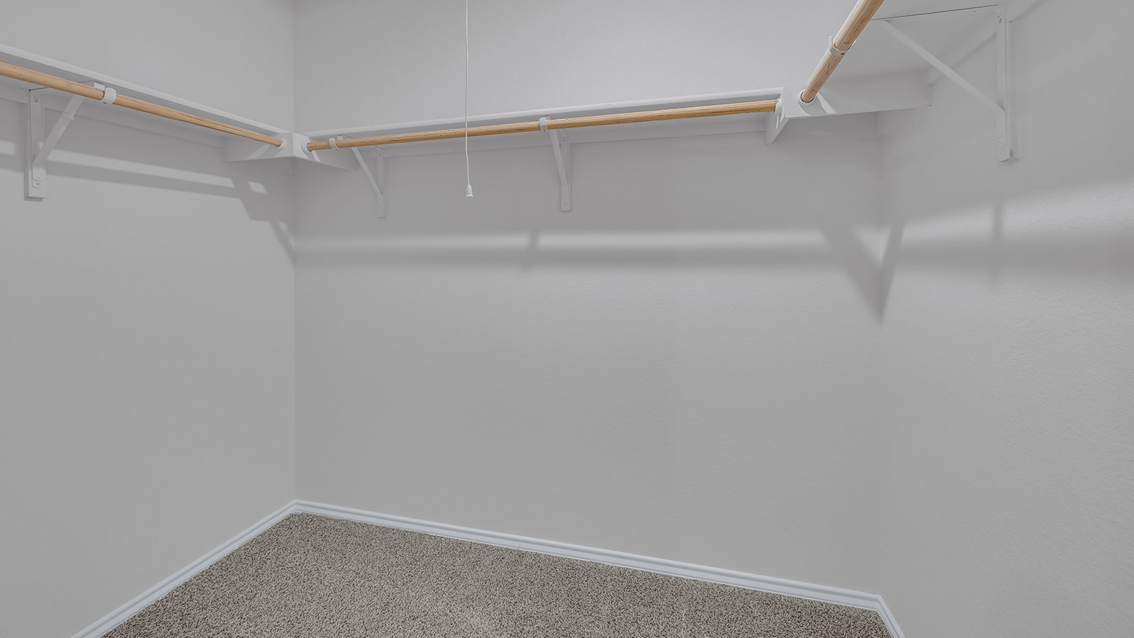 Main bedroom closet with carpeting and wooden shelving.