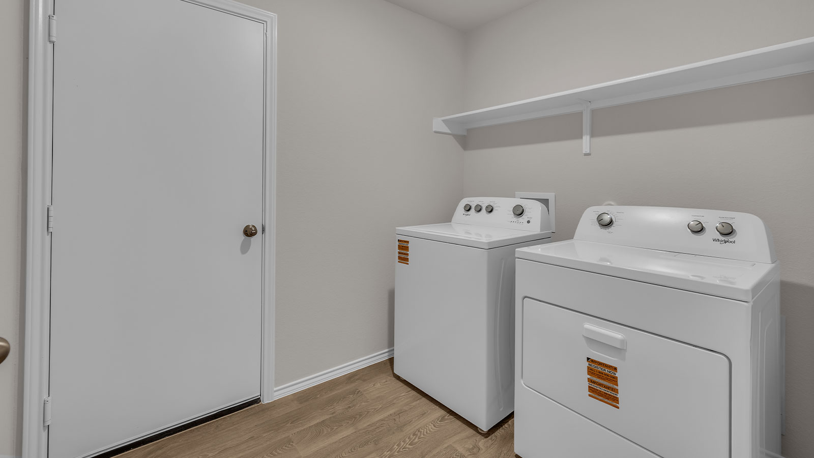 Utility room with washer/dryer connections and wooden shelving.