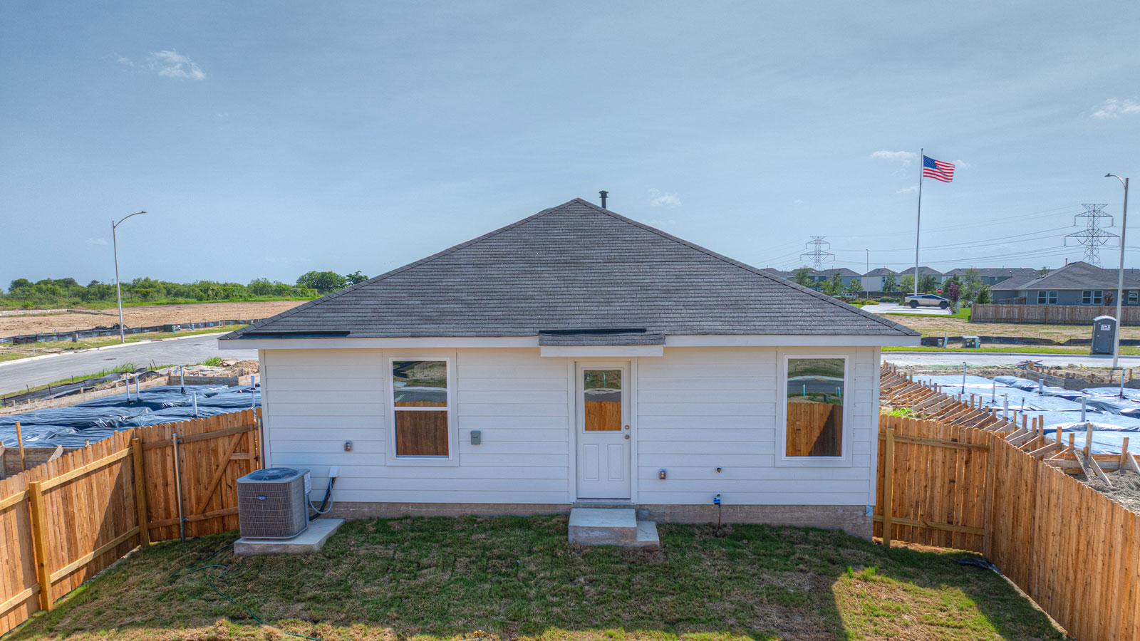 Backyard with 2 windows, and a half lite exterior door.