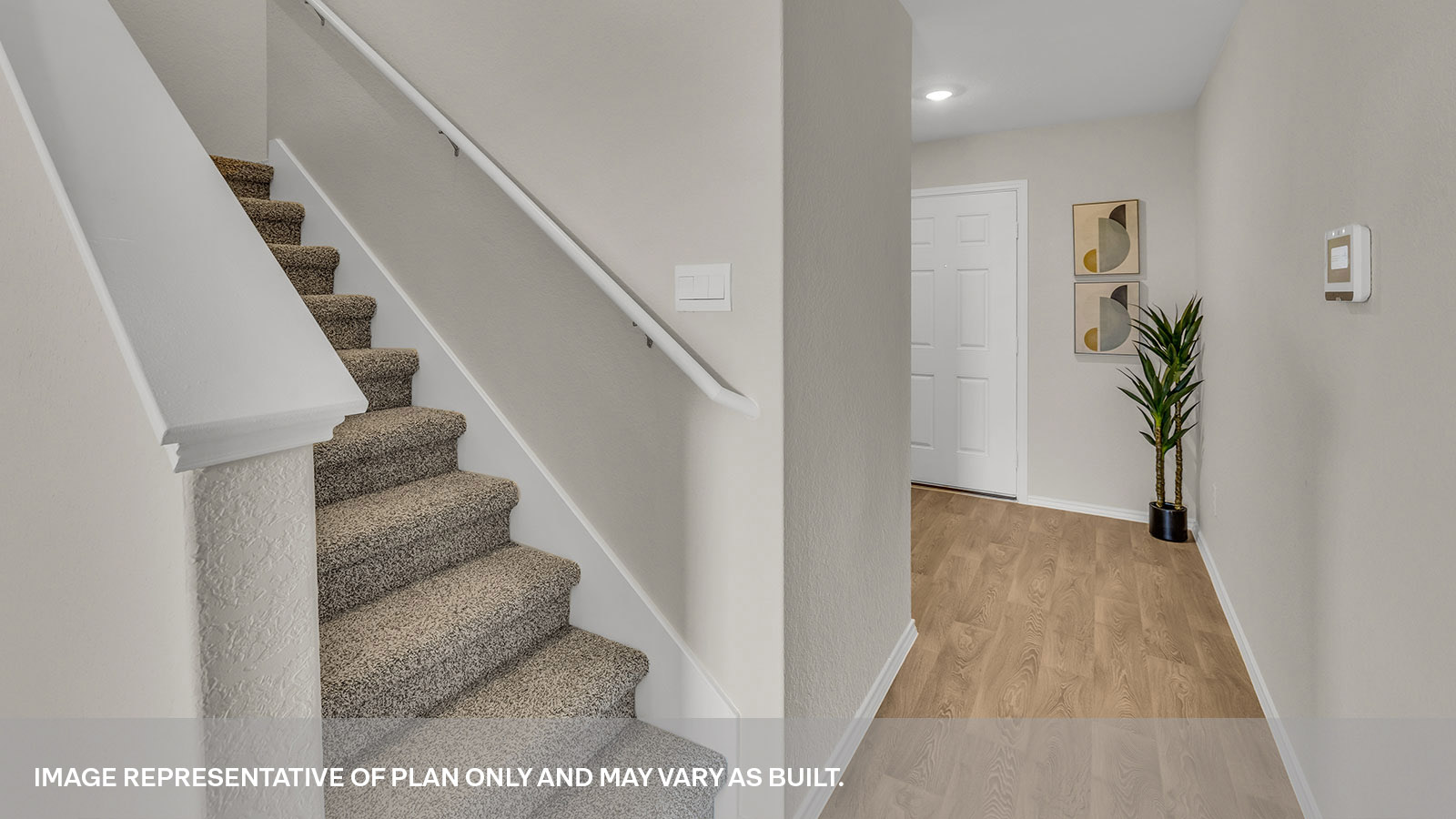 Entryway showing the front door and stairs with carpeting.
