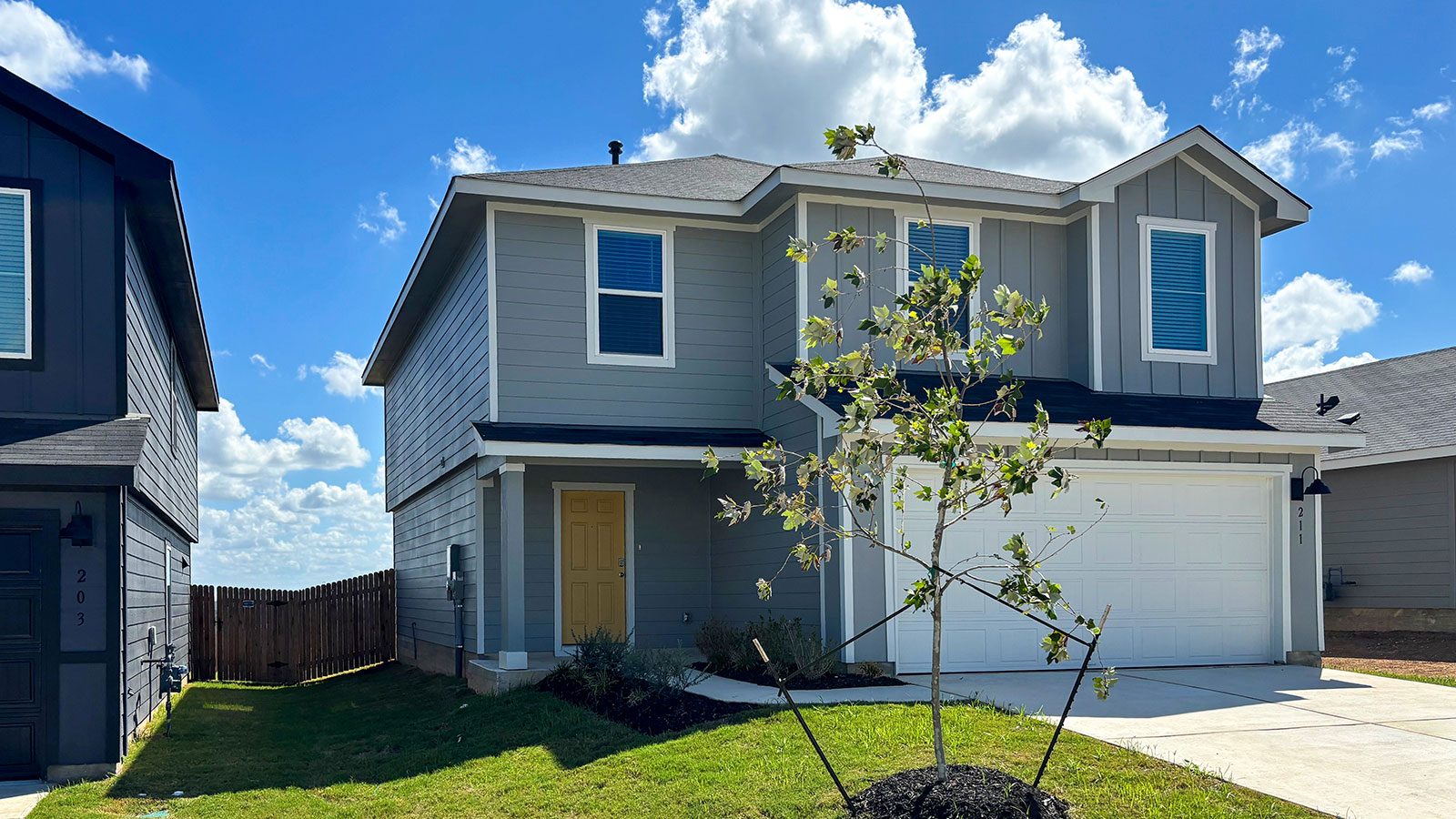 Two-story farmhouse exterior photo with 2 car garage.