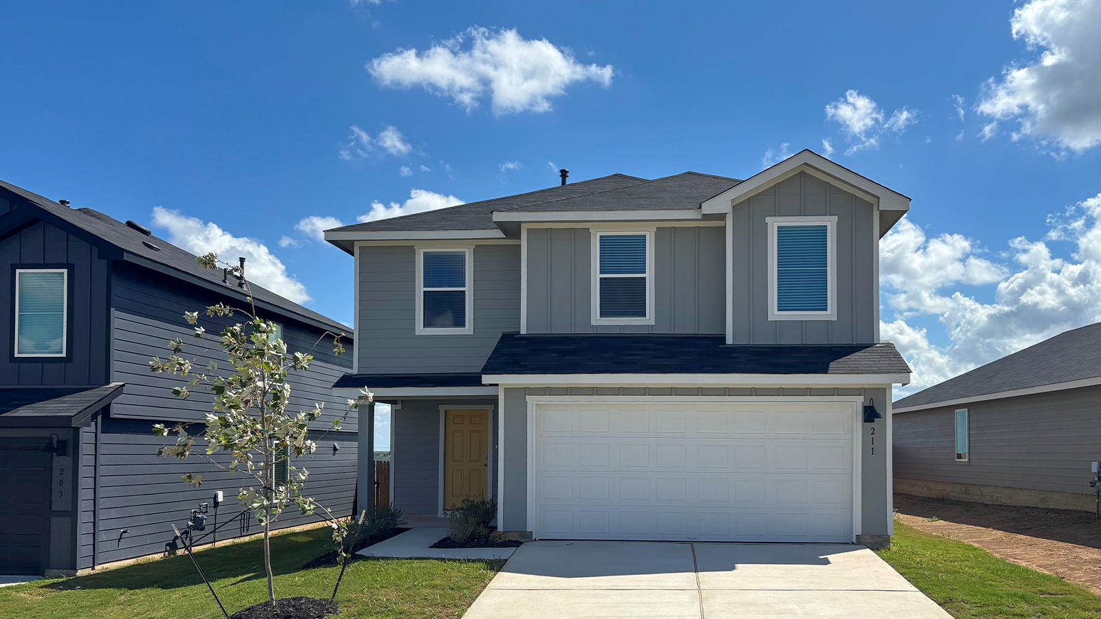 Two-story farmhouse exterior photo with 2 car garage.