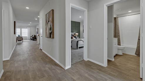 Entry hallway with vinyl flooring, hall bath, and bed 3.