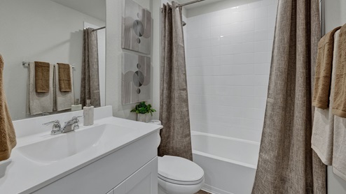 Hall bath with single sink vanity, toilet, and tub.