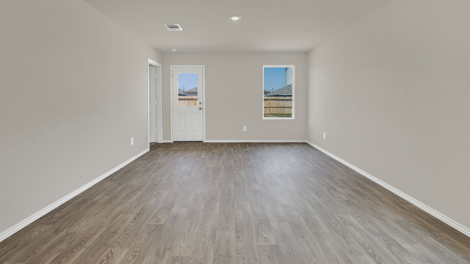 Living room with vinyl flooring, 2 windows, and a half lite exterior door.