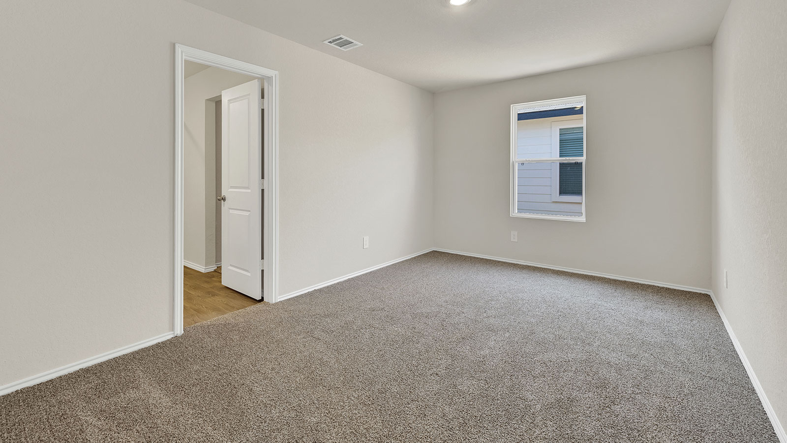 Main bedroom with carpeting and one window.
