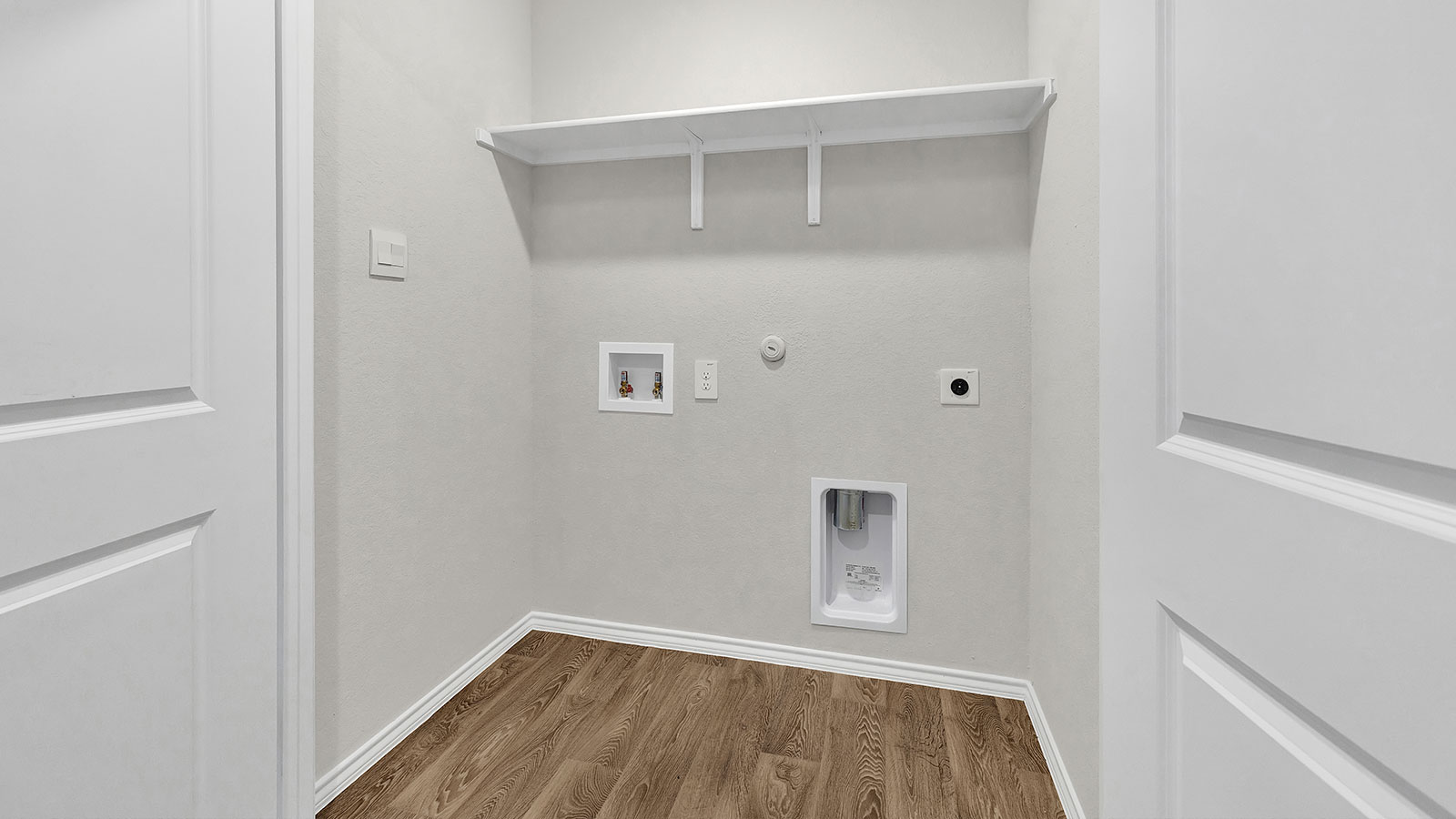 Laundry room with washer/dryer connection and wooden shelving.