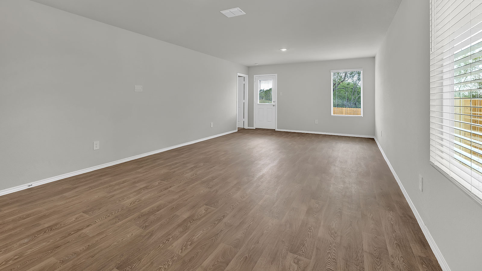 Living room with vinyl flooring, 2 windows, and  half lite exterior door.