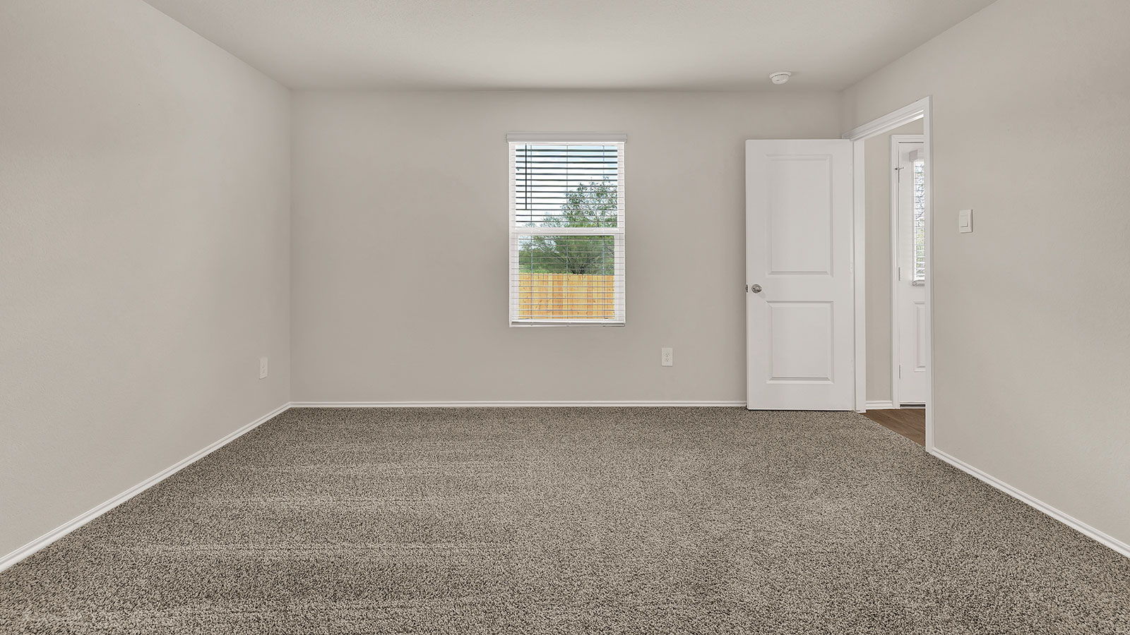 Main bedroom with carpeting and one window.