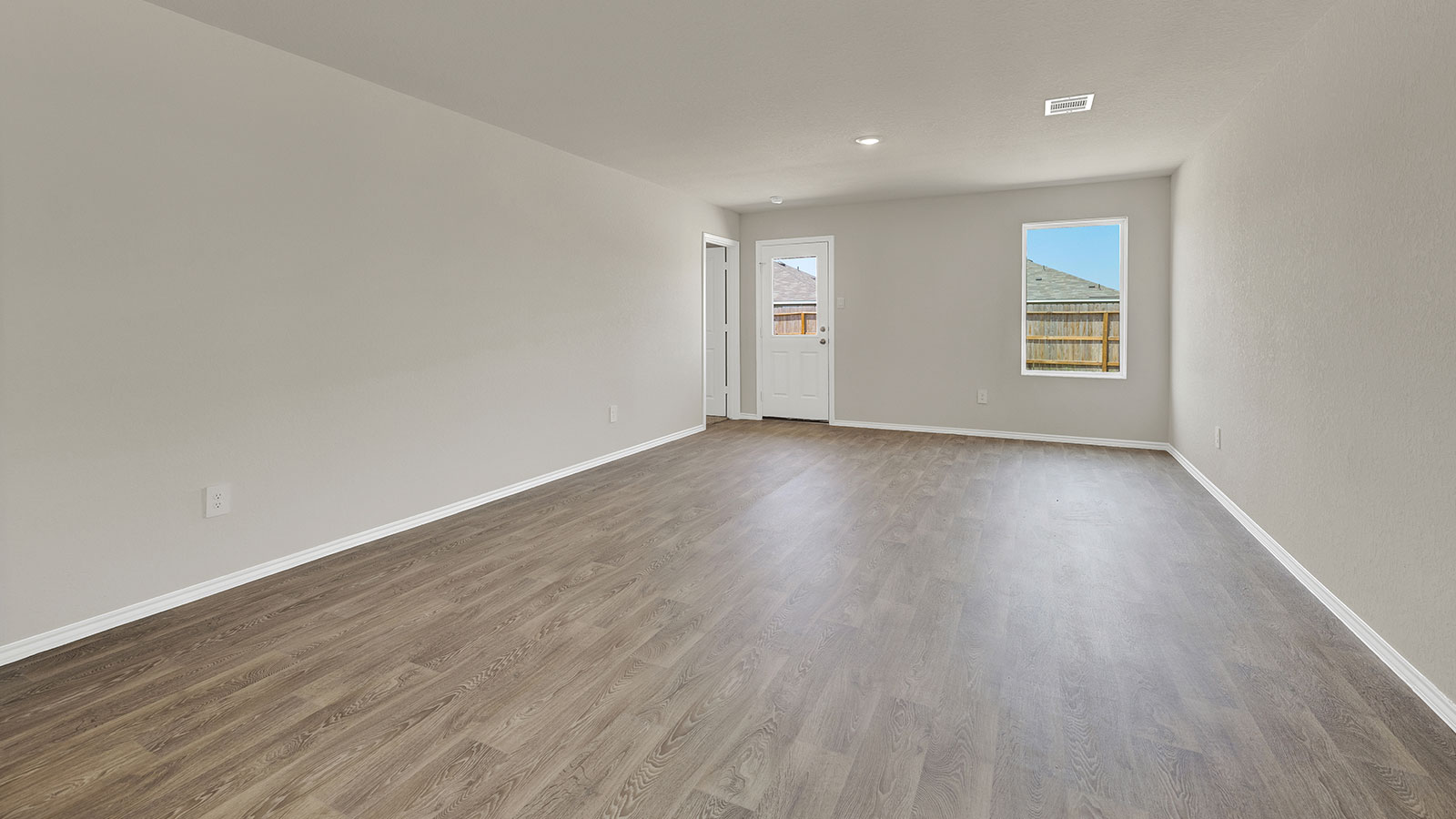 Living room with vinyl flooring, 2 windows, and  half lite exterior door.