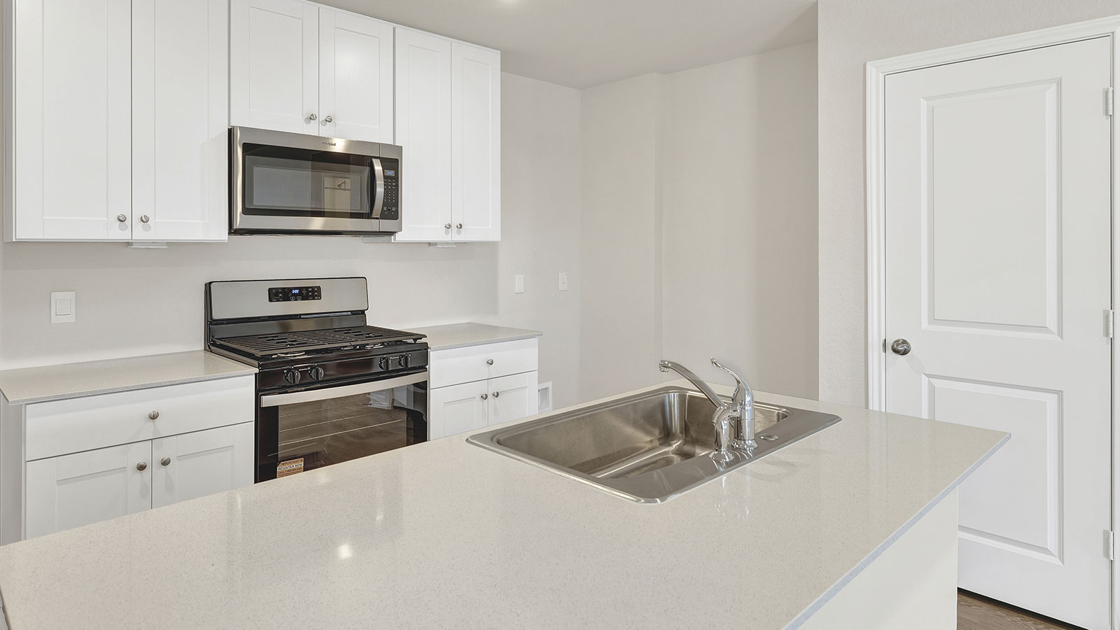 Kitchen with kitchen island and entry hallway.