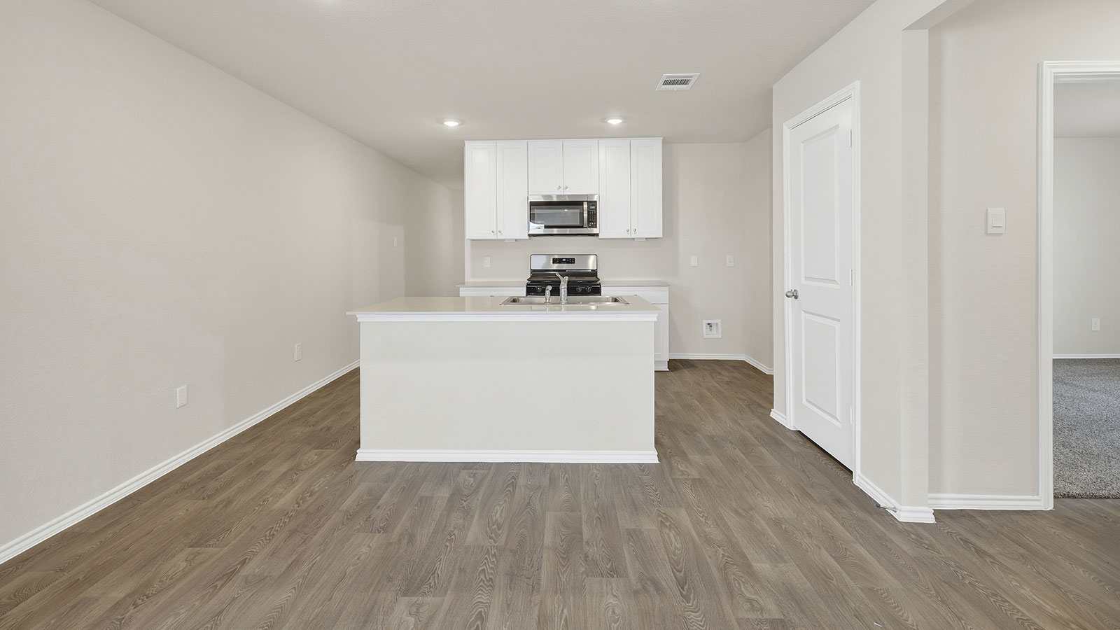 Kitchen with kitchen island and entry hallway.