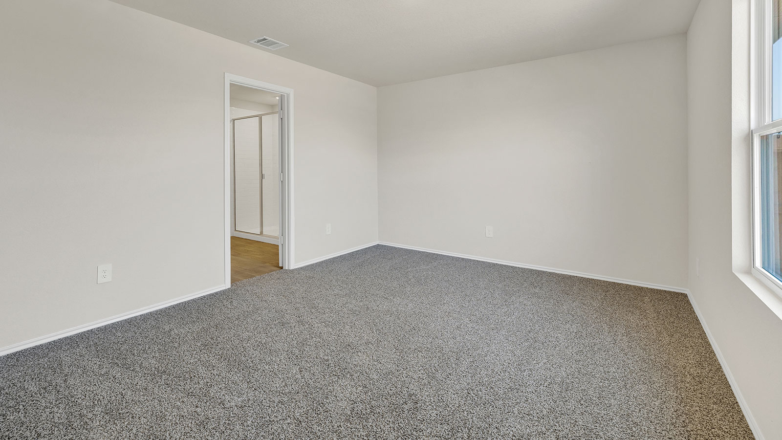 Main bedroom with carpeting and one window.