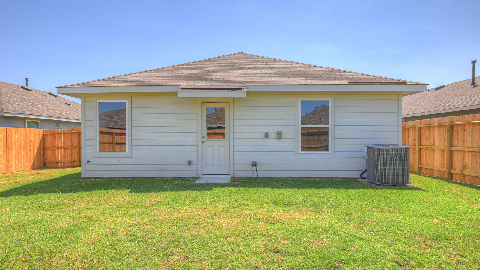 Backyard with 2 windows, and a half lite exterior door.