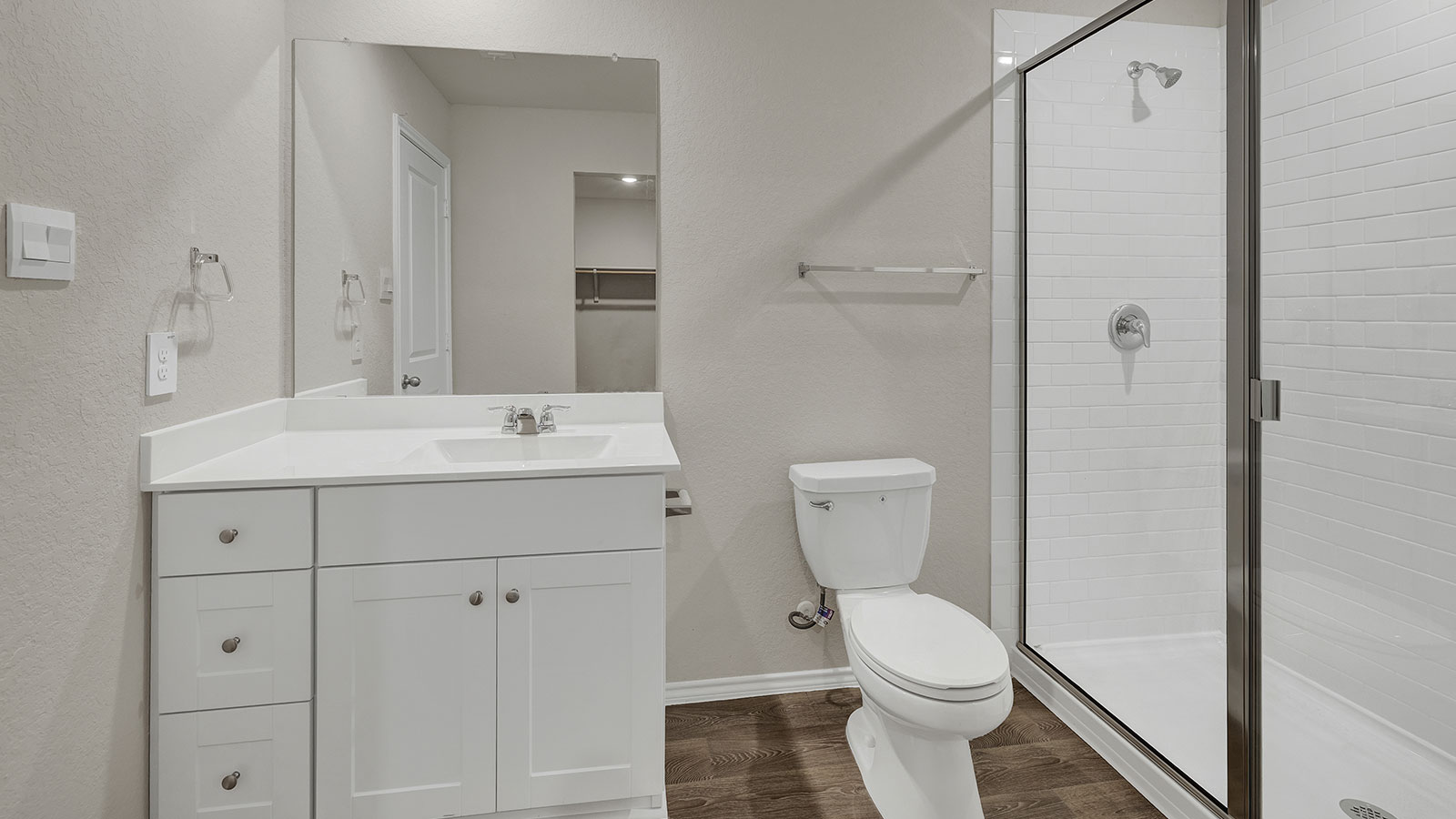 Main bathroom with vanity and walk-in shower with shower glass door.