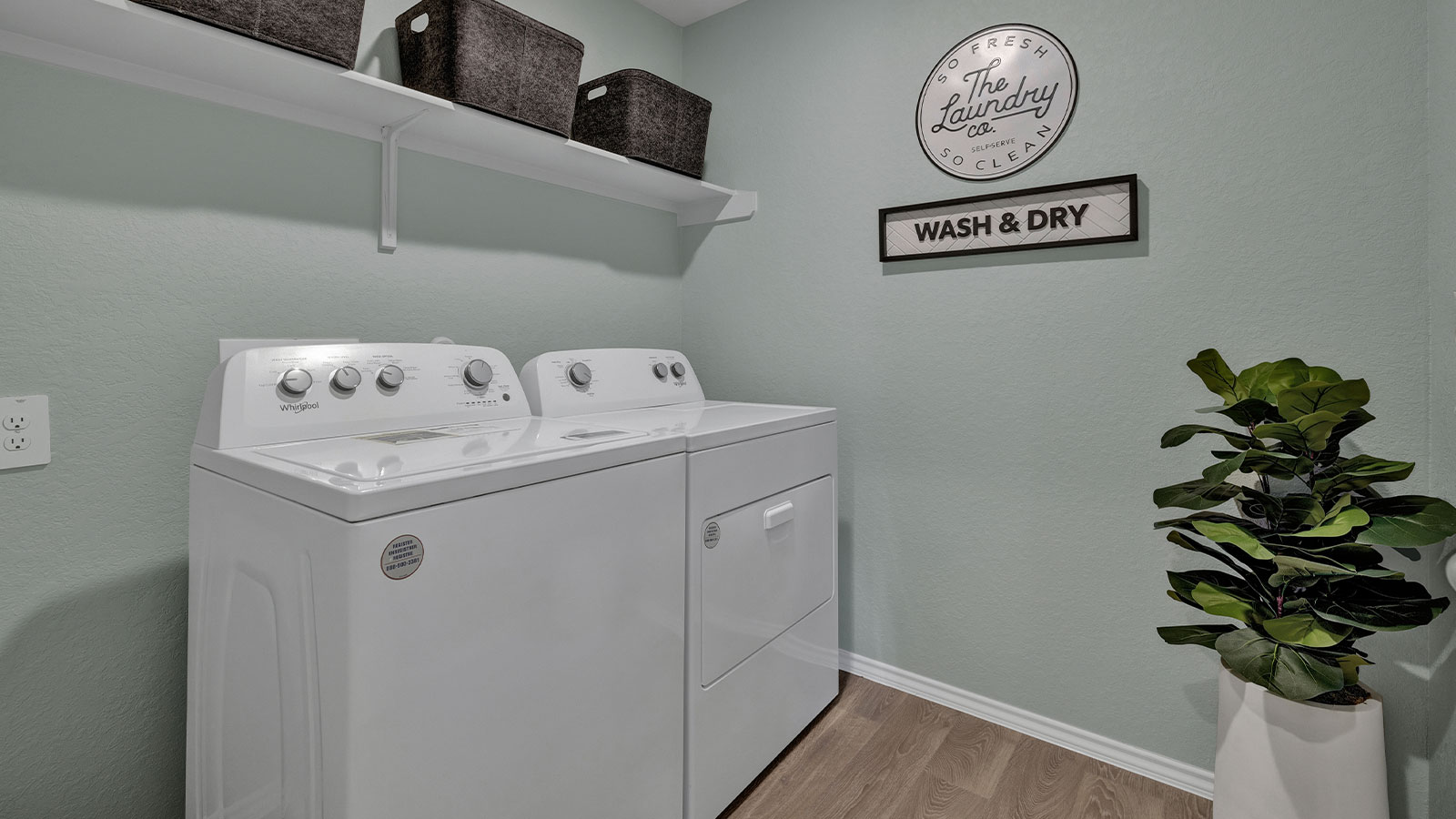 Laundry room with washer/dryer connections and wooden shelving.