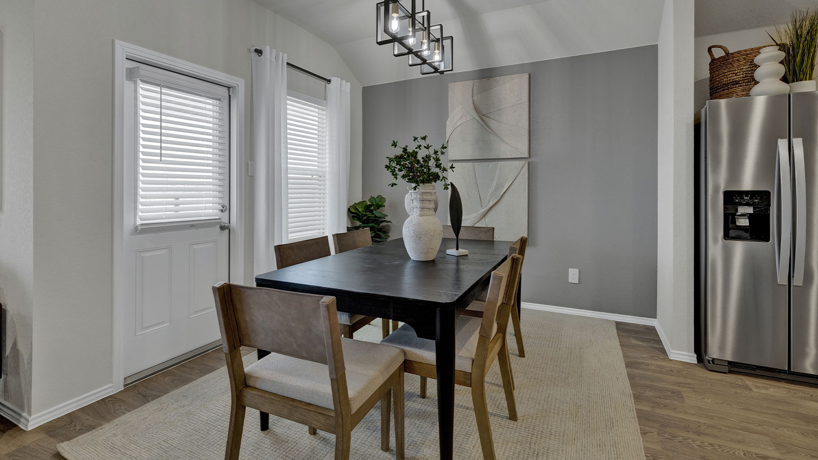 Dining room with vinyl flooring and two windows.