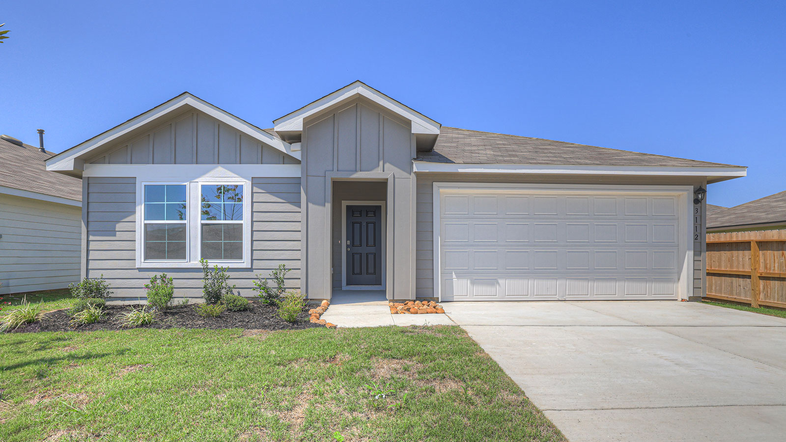 Single-story farmhouse exteriors with 2 car garage door and windows.