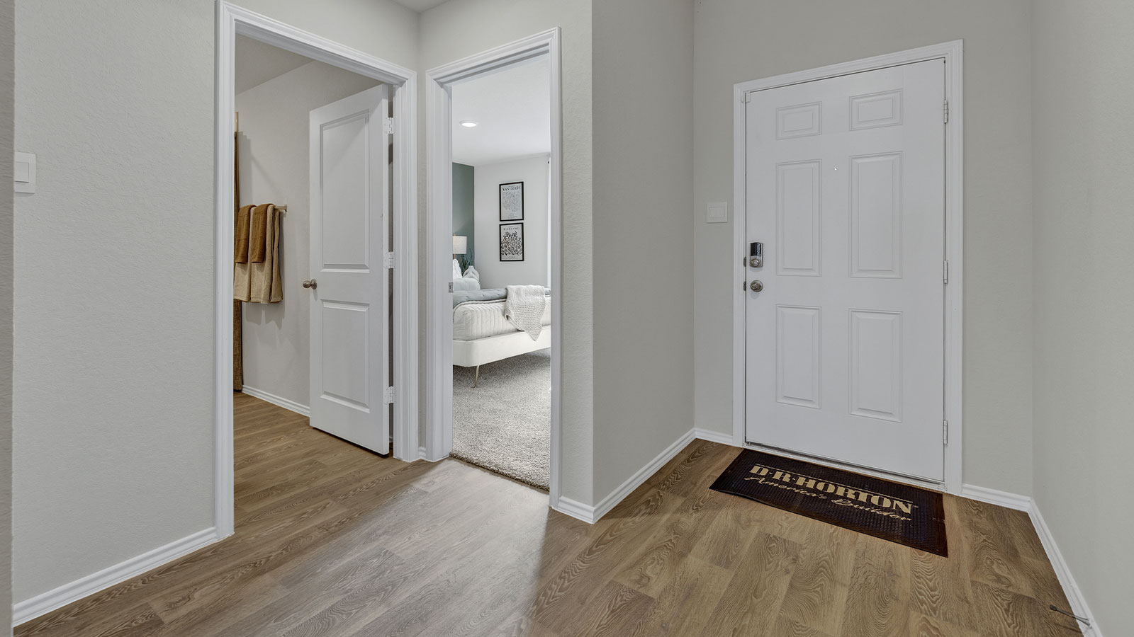 Entry hallway with vinyl flooring and front door.