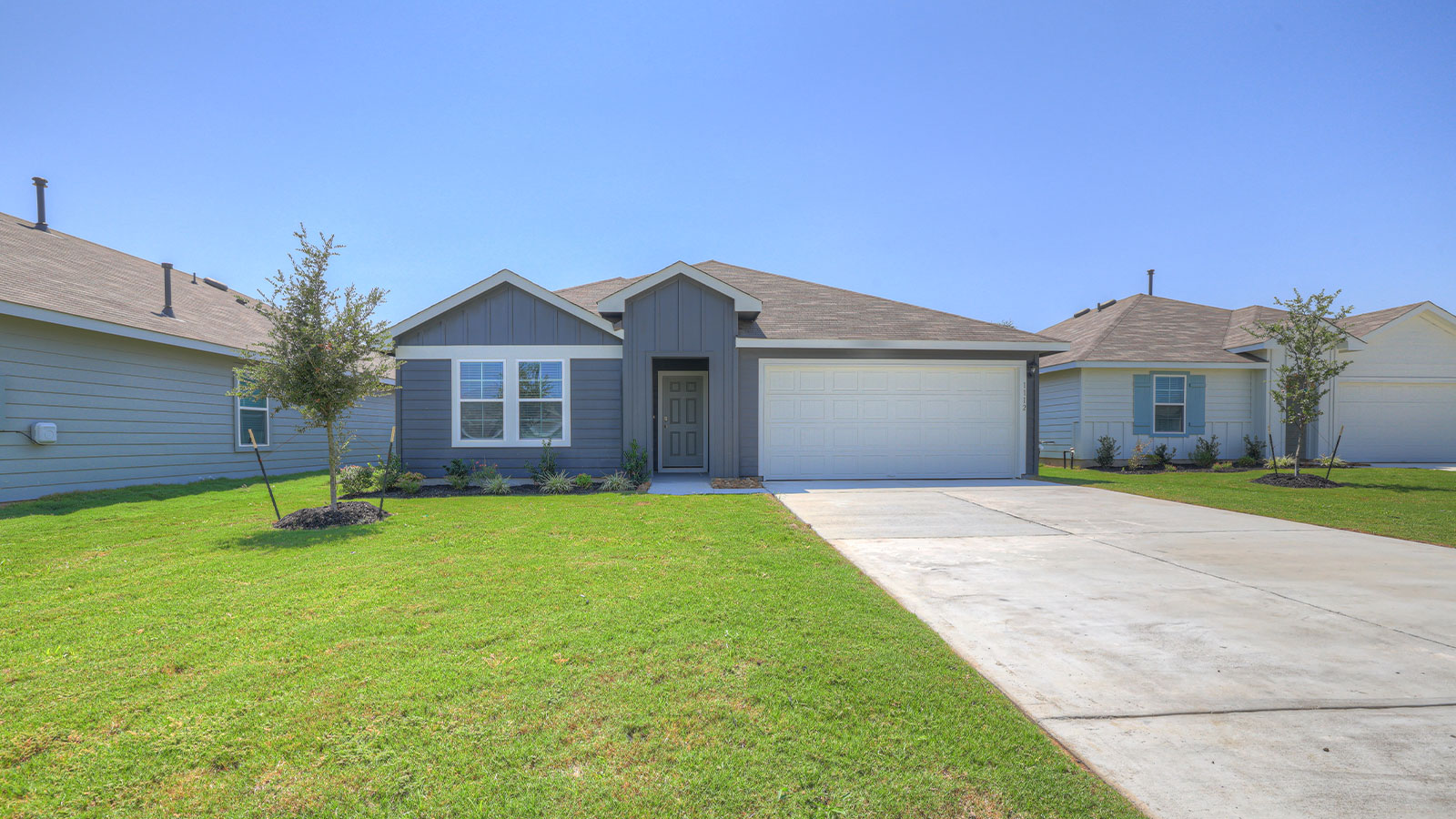 Single-story farmhouse exteriors with 2 car garage door and windows.