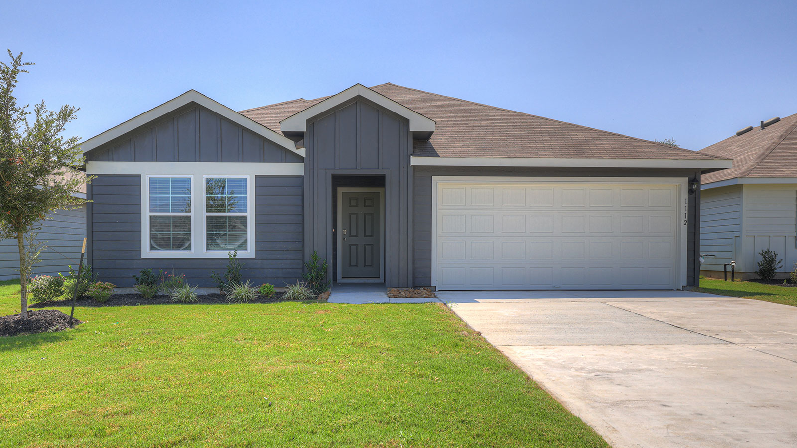 Single-story farmhouse exteriors with 2 car garage door and windows.