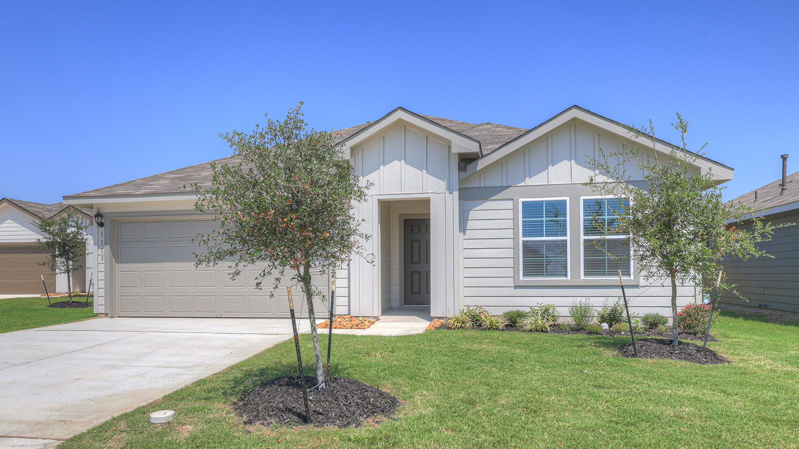 Single-story farmhouse exteriors with 2 car garage door and windows.