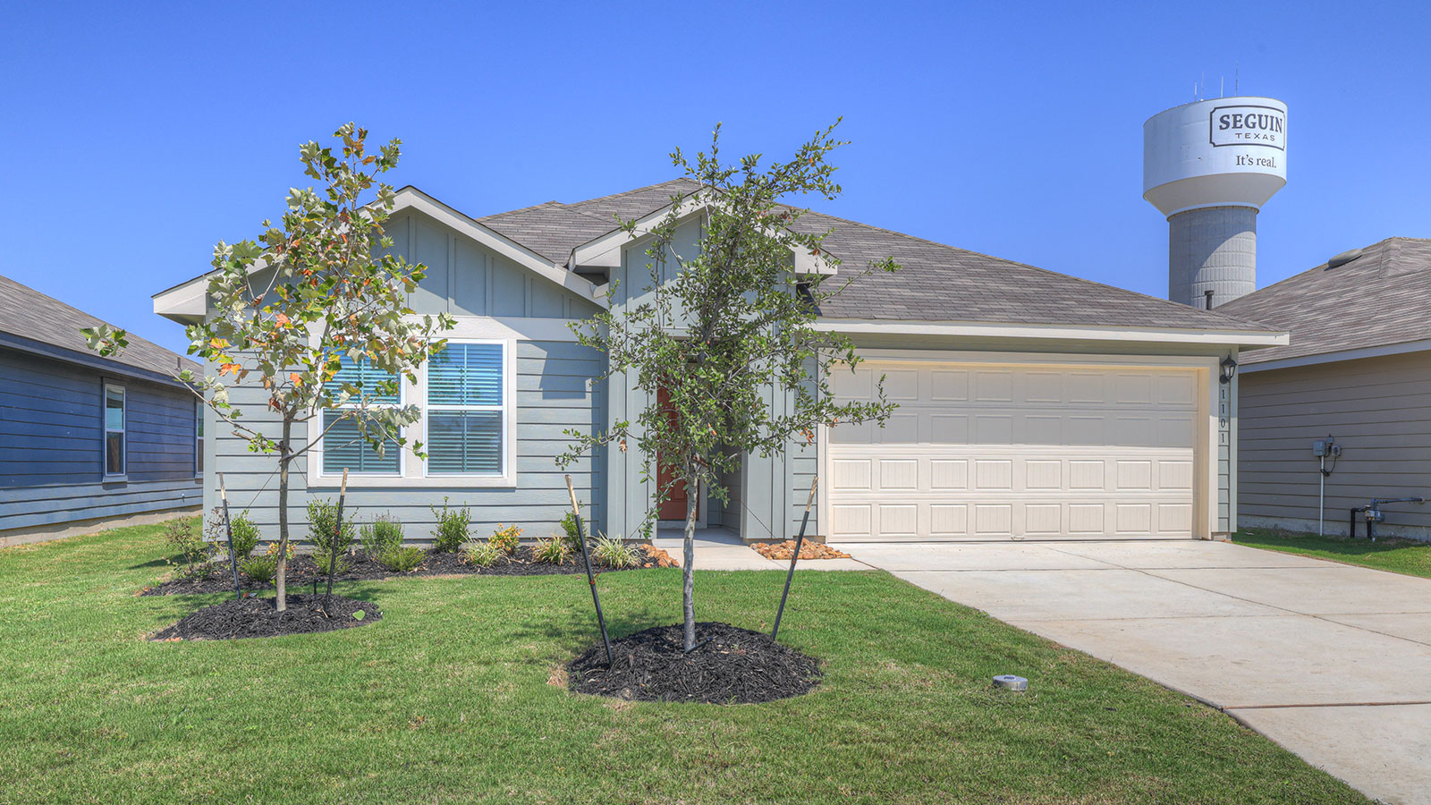 Single-story farmhouse exteriors with 2 car garage door and windows.