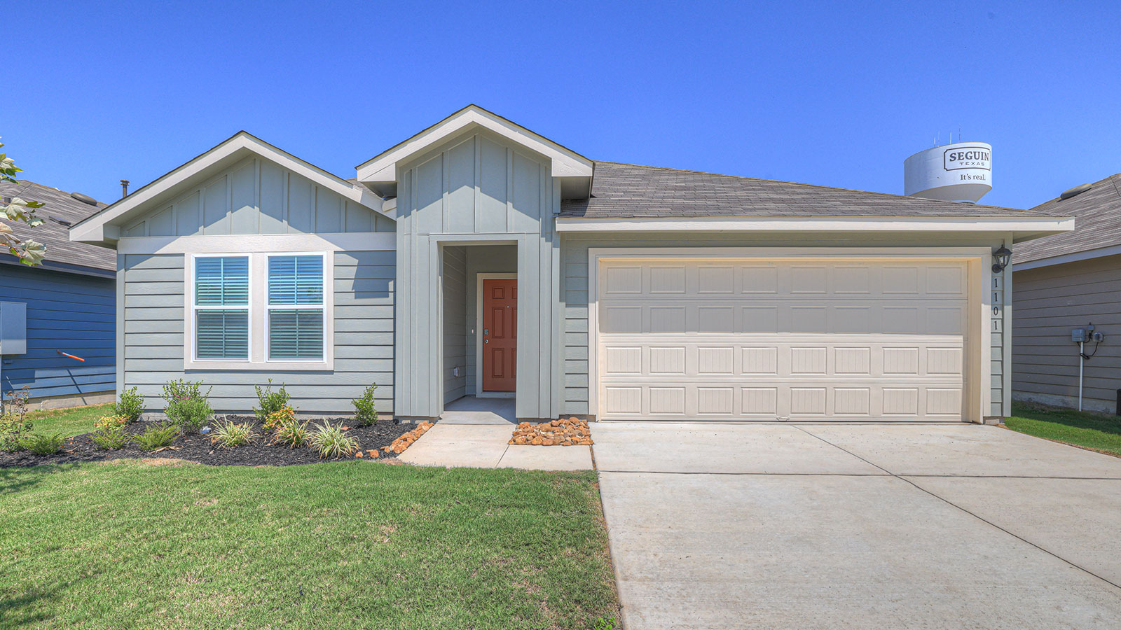 Single-story farmhouse exteriors with 2 car garage door and windows.