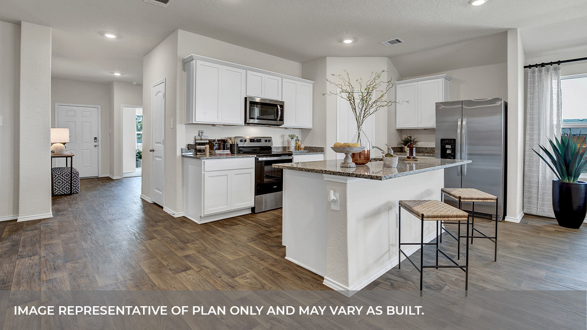 Kitchen with white cabinets and entry hallway.