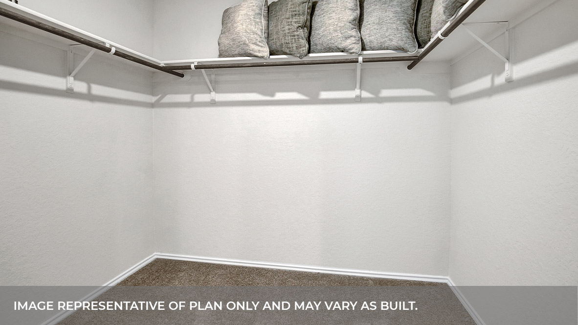 Main bedroom closet with carpeting and wooden shelving.
