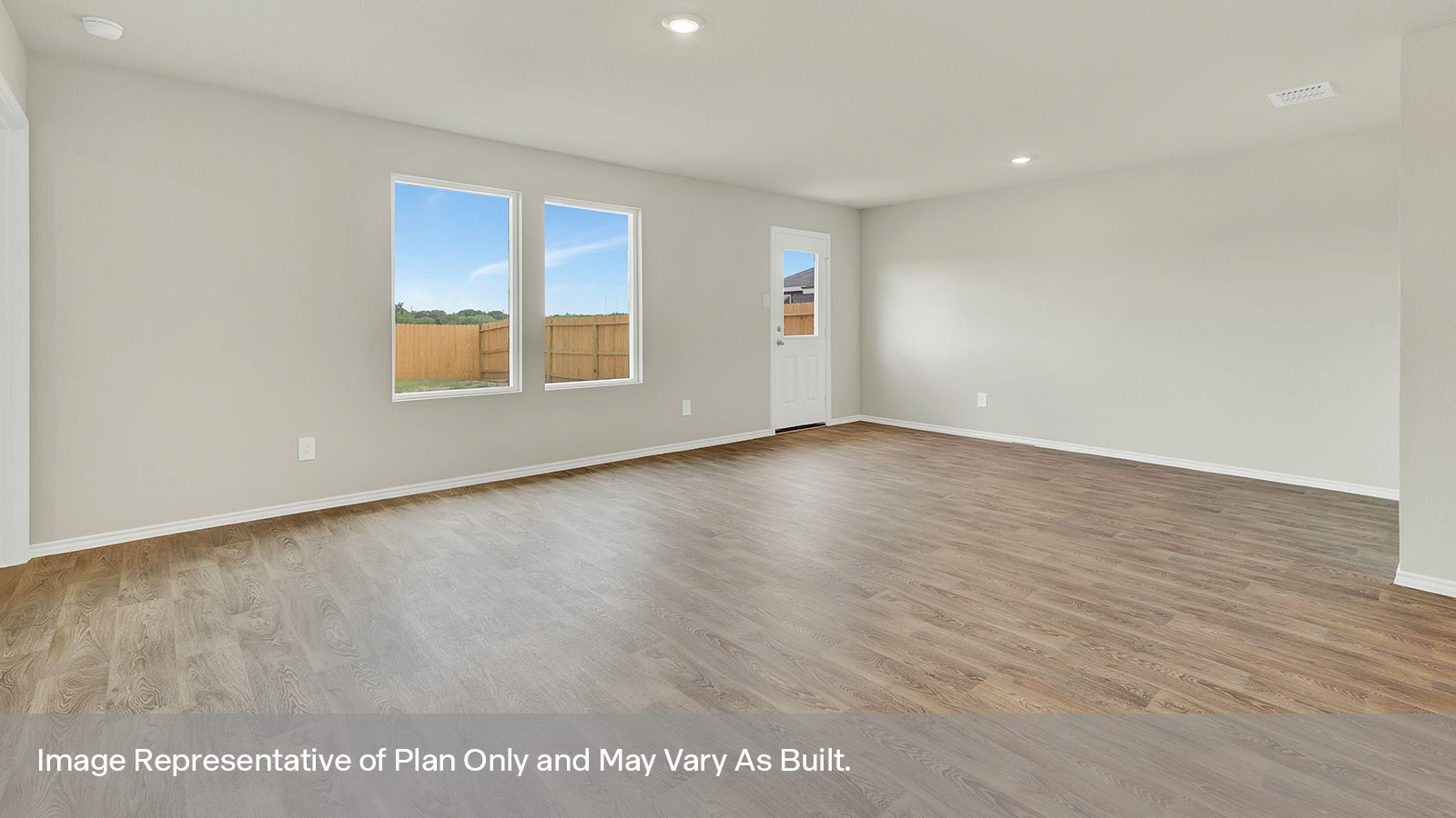 Living room and dining room with vinyl flooring, two windows, and a half lite exterior door.